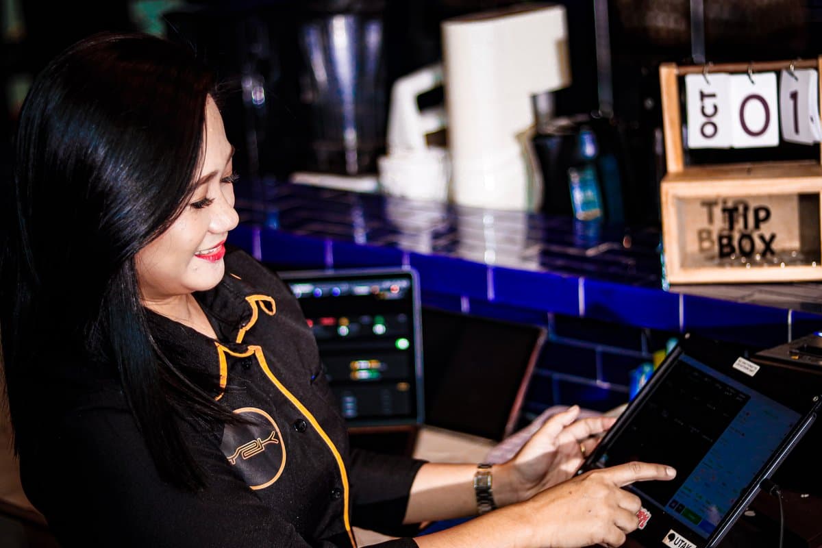 Smiling staff member taking an order on the tablet