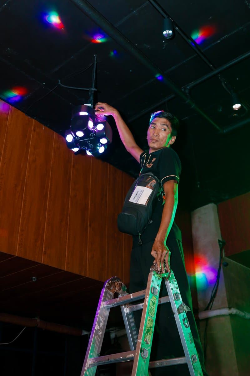 Technician on a ladder rigging the party lights